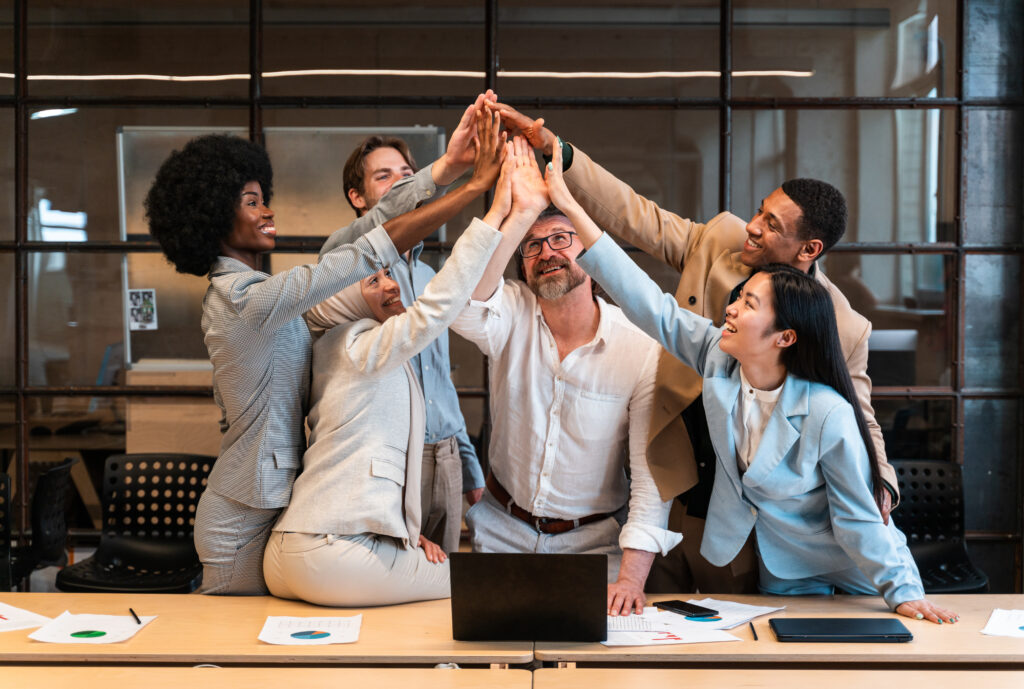 A team of professionals joining hands in the office, demonstrating incredible culture