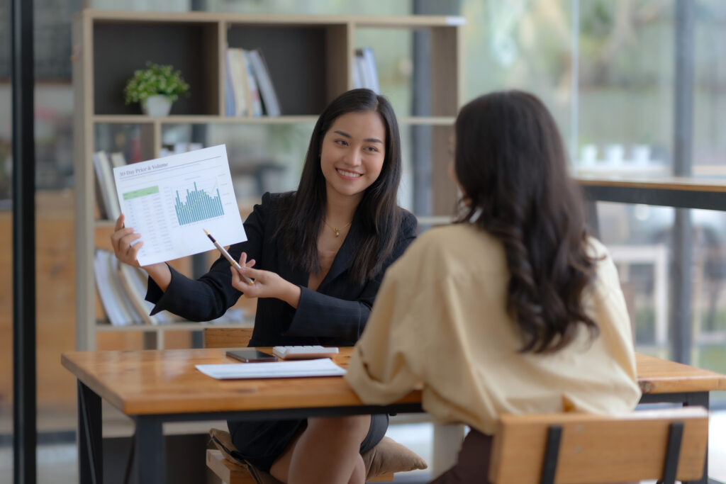 A business professional delivering a pitch to her client in a more relaxed office setting.